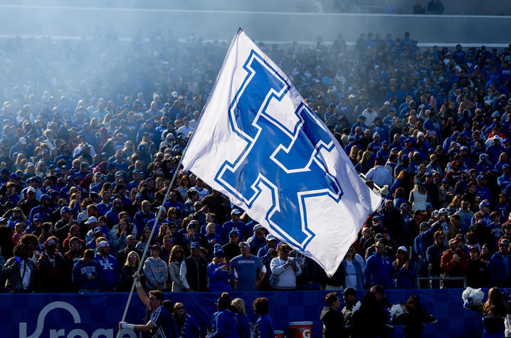 A University of Kentucky flag waving in front of football fans. 