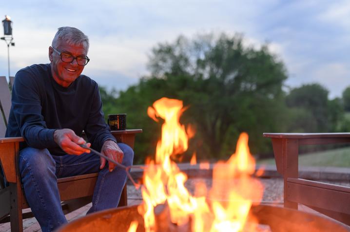 Man sitting next to a campfire