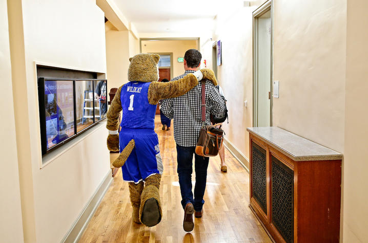 photo of wildcat and faculty member walking 