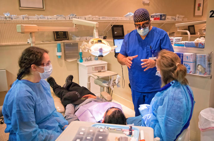 This is a photo of students with the Hispanic Student Dental Association learning and working with patients at the Mission Clinic.