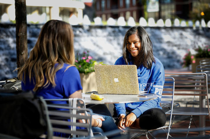 photo of two girls with laptop