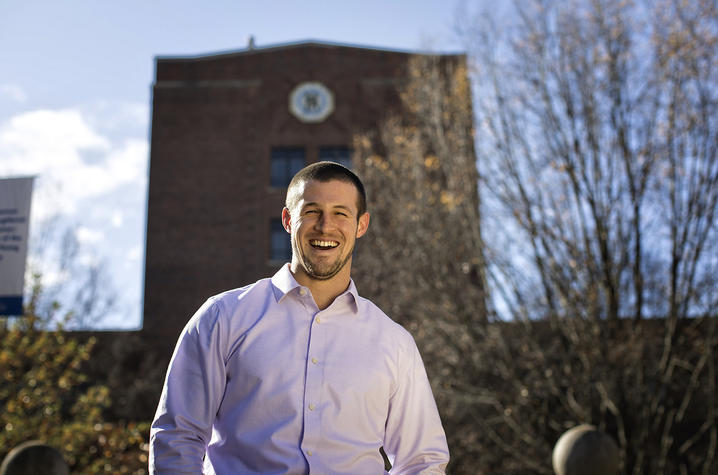 Alex Elswick smiling while standing in front of the Funkhouser building