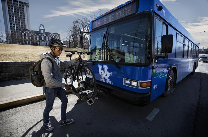 photo of man adding bike to bus