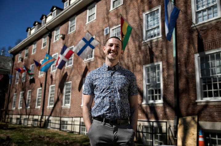 Photo of Trey Cardwell stands in front of a building adorned with flags Photo by Mark Cornelison | UK Photo