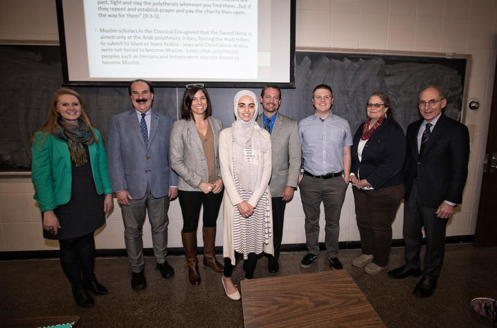 photo of administrators, faculty and mentors with Hadeel Abdallah in front of chalkboad
