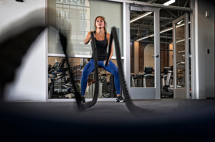 photo of woman working with ropes - Alumni Gym