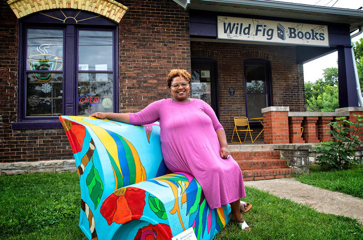 photo of Crystal Wilkinson seated on her book's bench outside Wild Fig