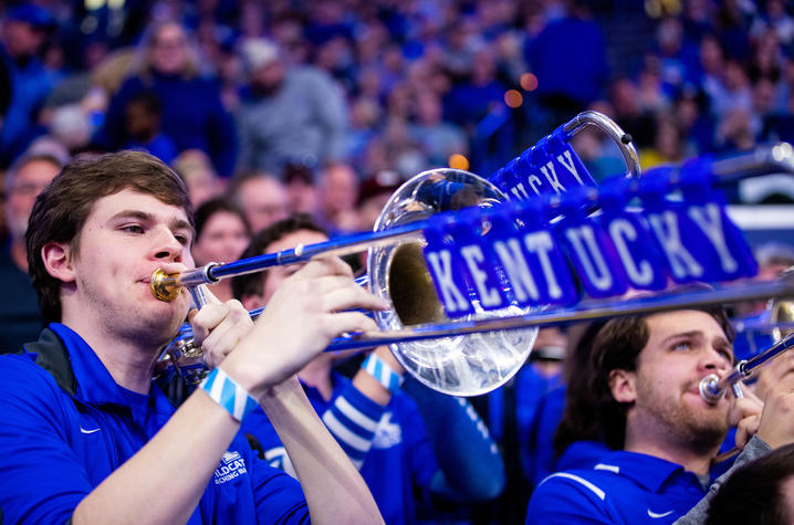 photo of John Schulz with blue tiles spelling out Kentucky on trombone slide