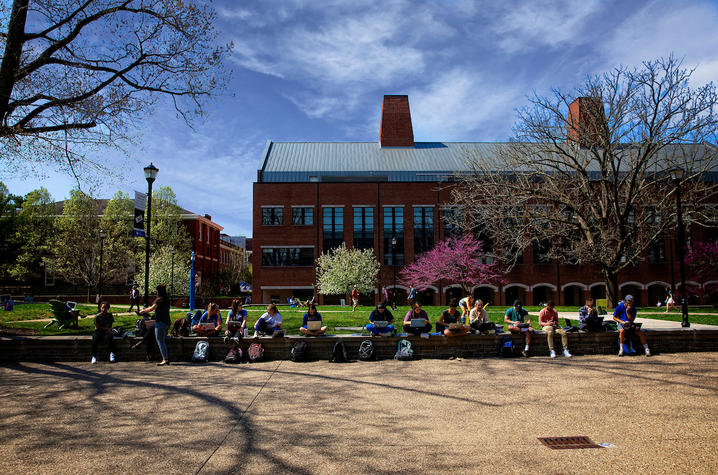 Photo of students sitting outside of Whitehall Classroom Building.