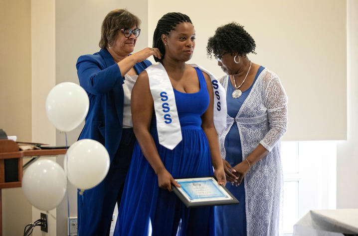 photo of 2 Student Support Services staff members presenting honors to student