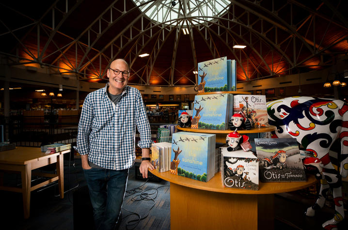 photo of Loren Long beside a table display of his books at Joseph-Beth