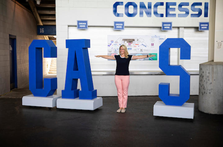 Staff member posing with the CATS sign. 
