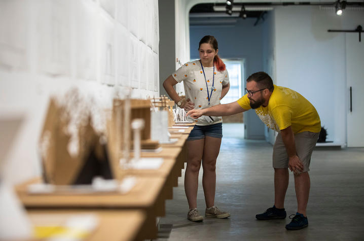 photo of 2019 GSA student and adult looking at model from Architecture + Design