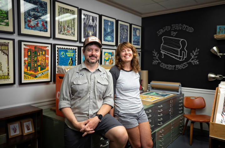 Brian and Sara Turner at Cricket Press in front posters of their work