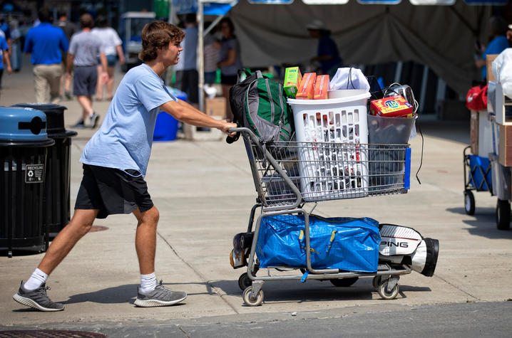 male student pushing a cart full of items for his residence hall at Move-In 2019