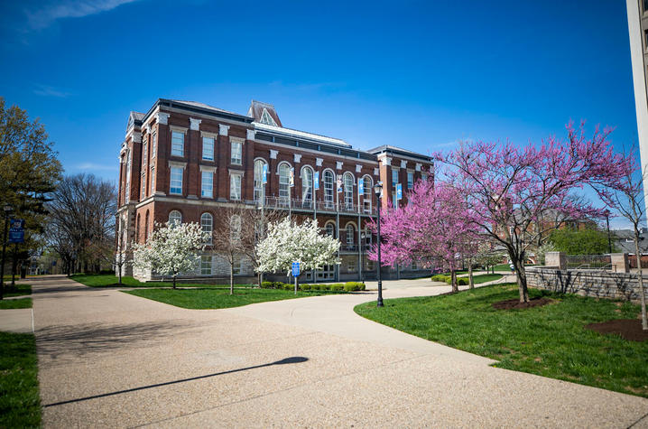 photo of Main Building from a distance through budding trees