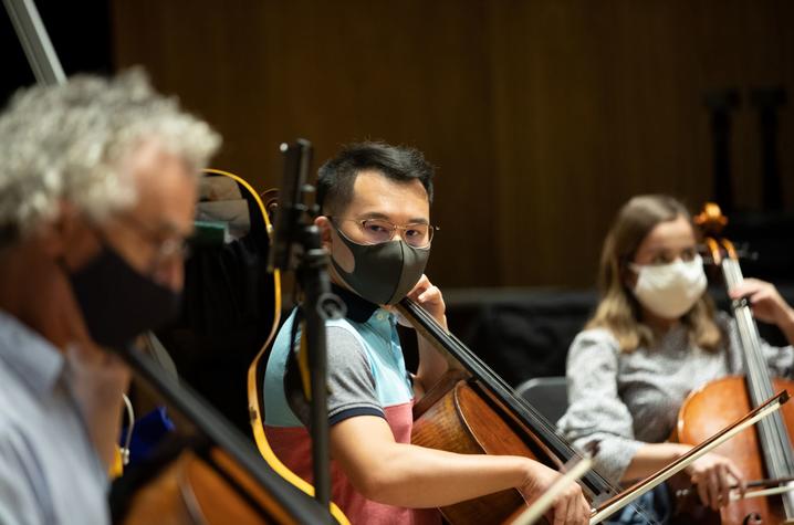 photo of masked Professor Benjamin Karp playing with 2 student musicians