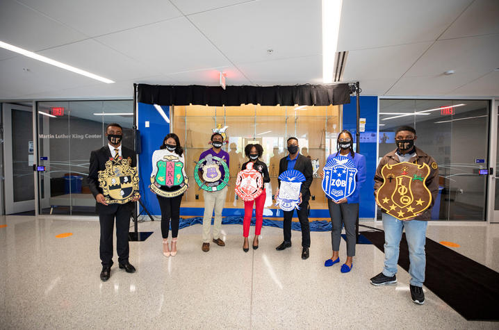 NPHC fraternity and sorority members hold crests