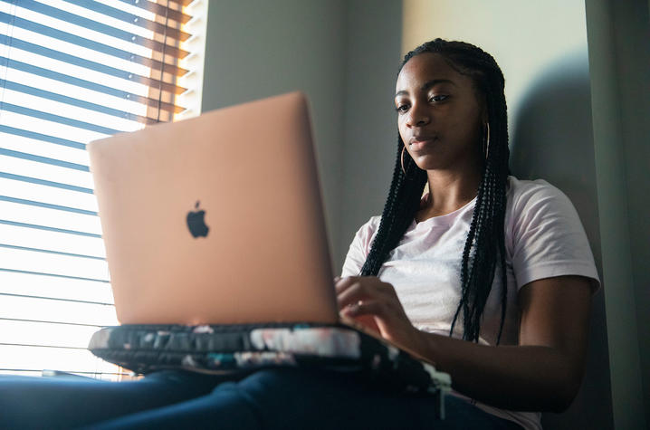 photo of UK student in residence hall on laptop