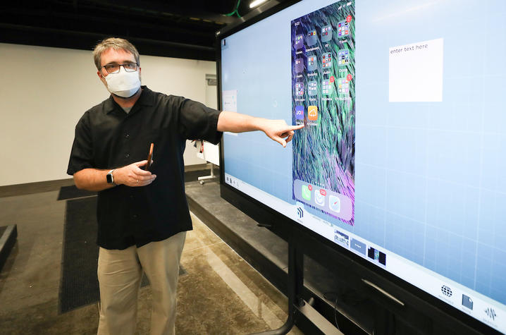 Faculty member teaching while wearing a mask.