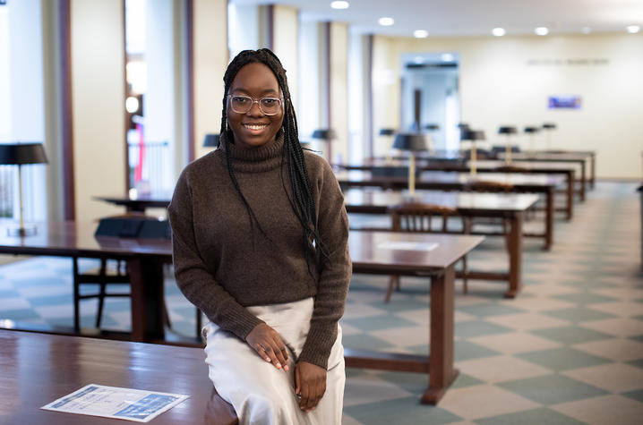 photo of Chimene Ntakarutimana seated on table in Young Library