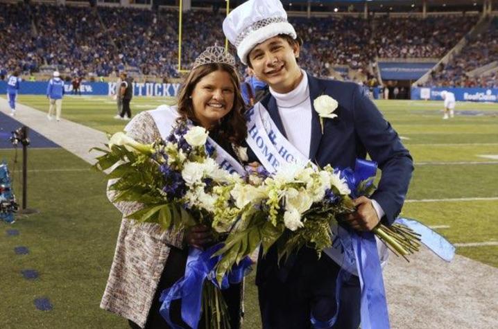 Gracelyn Bush and Johnny Zelenak II in homecoming crowns and sashes with flowerss