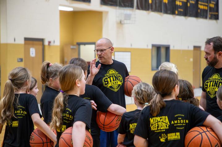 Photo of Dan Zuber talking to a group of middle school basketball players
