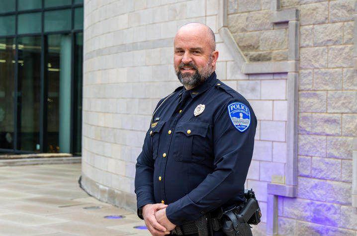 Capt. Chuck Adams smiling in his UKPD uniform in front of the student center