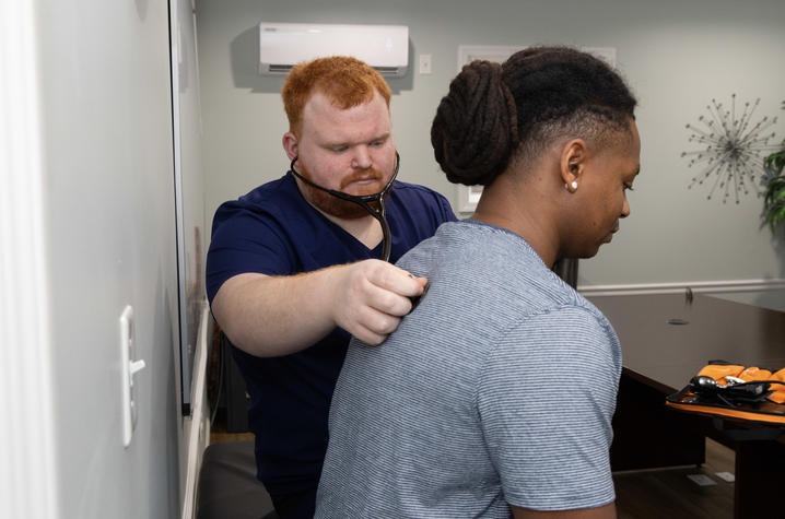 Alex Willett performing a physical on a CATS Clinic patient