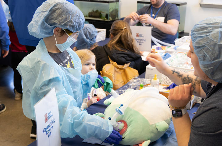 Image of little boy pretending to do surgery on his stuffed animal.