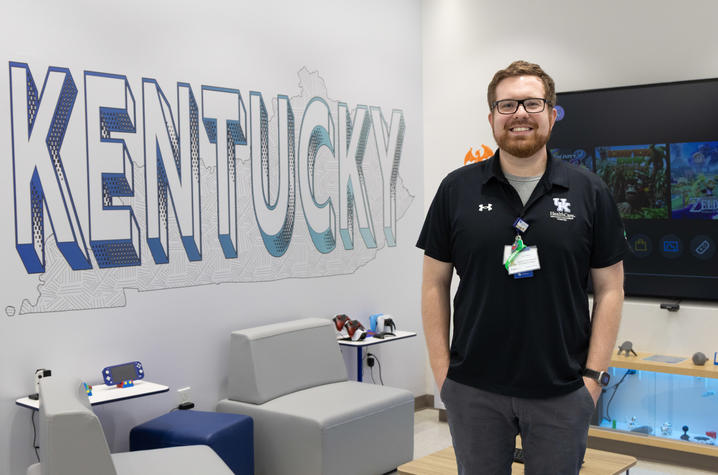 Image of Cody Dean standing in front of video game screen