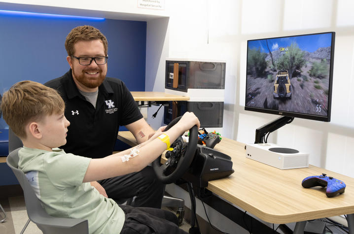 Image of KCH patient playing a video game while Cody Dean watches