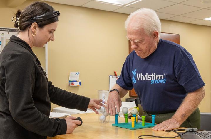 Nick Lewis’ therapy team customizes sessions to real-life goals — like placing a tee and a golf ball to prepare Lewis for one day teeing it up again. Photo by Hilary Brown.