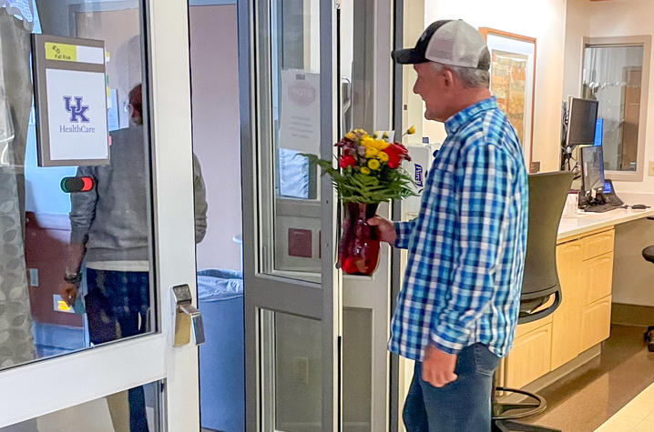 Image of Bobby walking into a hospital room with flowers