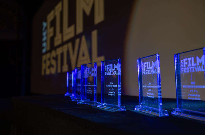 Glass awards illuminated in blue light at a film festival ceremony.