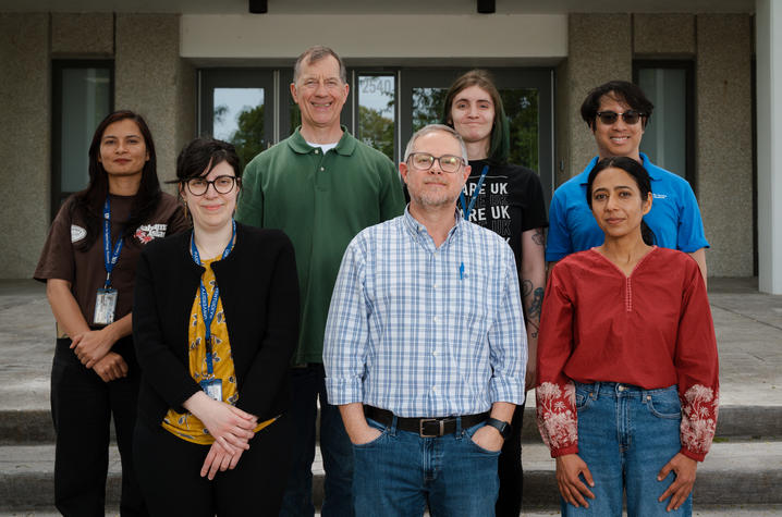 Seven people standing outside a building.