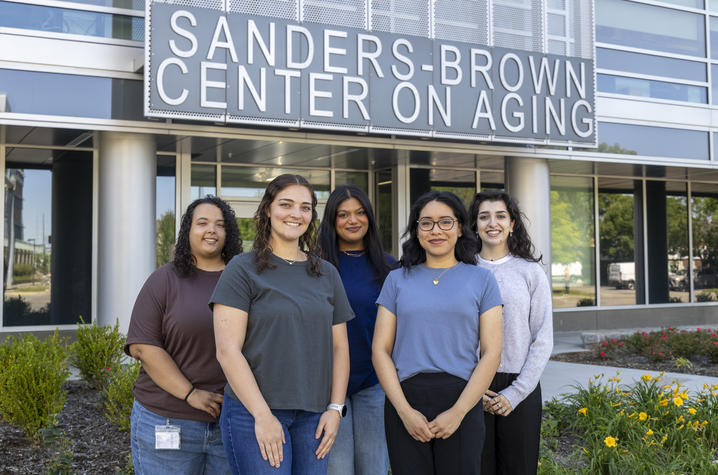 Trainees at the Sanders-Brown Center on Aging Five students stand together outside the Sanders-Brown Center on Aging, smiling for a group photo beneath the center’s sign.