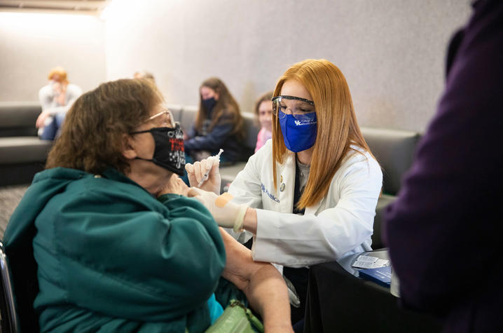 photo of student administering COVID vaccine