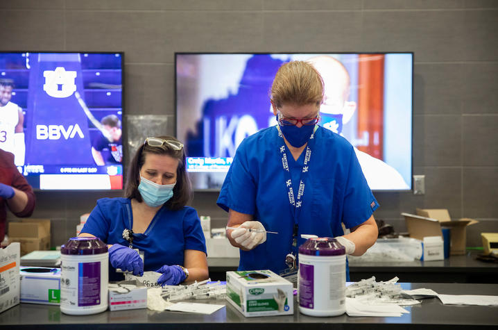 image of two nurses preparing covid vaccines at the UK vaccine clinic