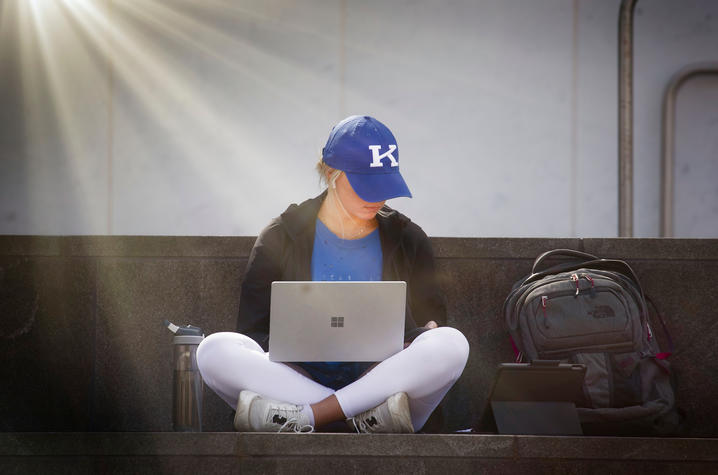 Photo of student sitting outside on her laptop