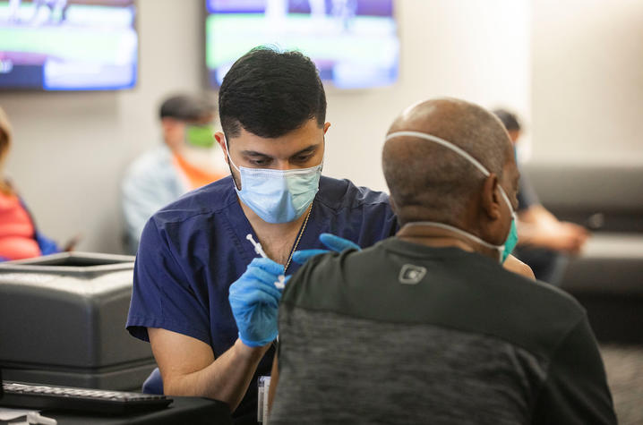 Photo of frontline worker administering COVID-19 vaccine at Kroger Field Clinic