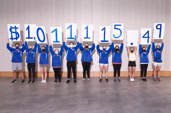 Photo of students holding up signs revealing the DanceBlue fundraising total of $1,011,115.49.