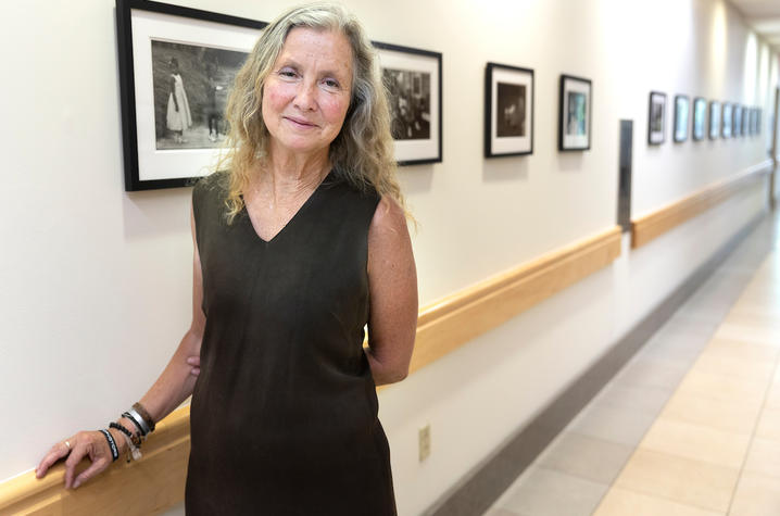 Photo of photographer Sarah Hoskins in front of exhibition