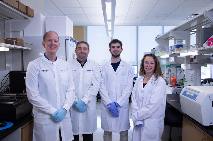 Ebbert lab team, four scientists in white lab coats