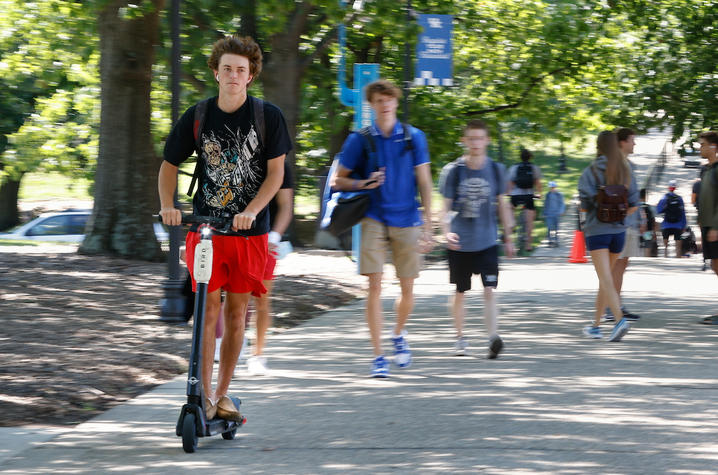 Student riding scooter. 