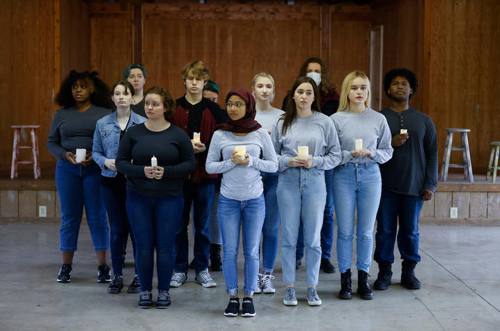 photo of cast members in pyramid holding candles from UK Theatre's "The Laramie Project"