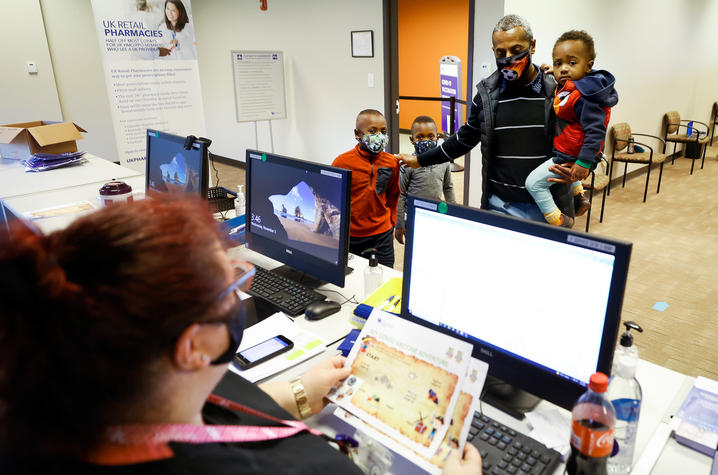 Image of father and three children at registration desk