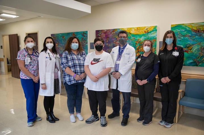 Image of 12-year-old Tyson with his care team in clinic