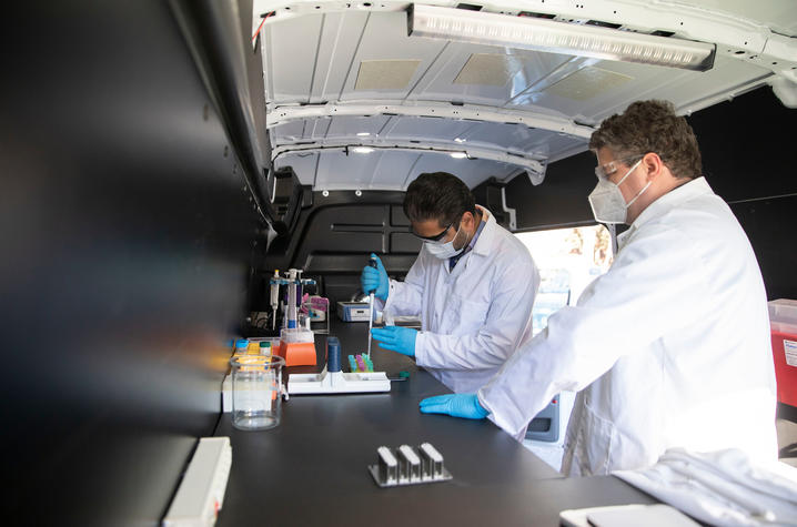 UK researchers Soroosh Torabi and Scott Berry in the "Disease Detective" mobile lab. Pete Comparoni | UK Photo
