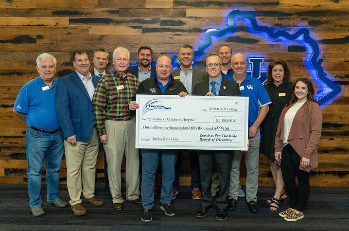 image of Coach Stoops with the Coaches for the Kids Board of Directors presenting a check to Dr. Scottie Day